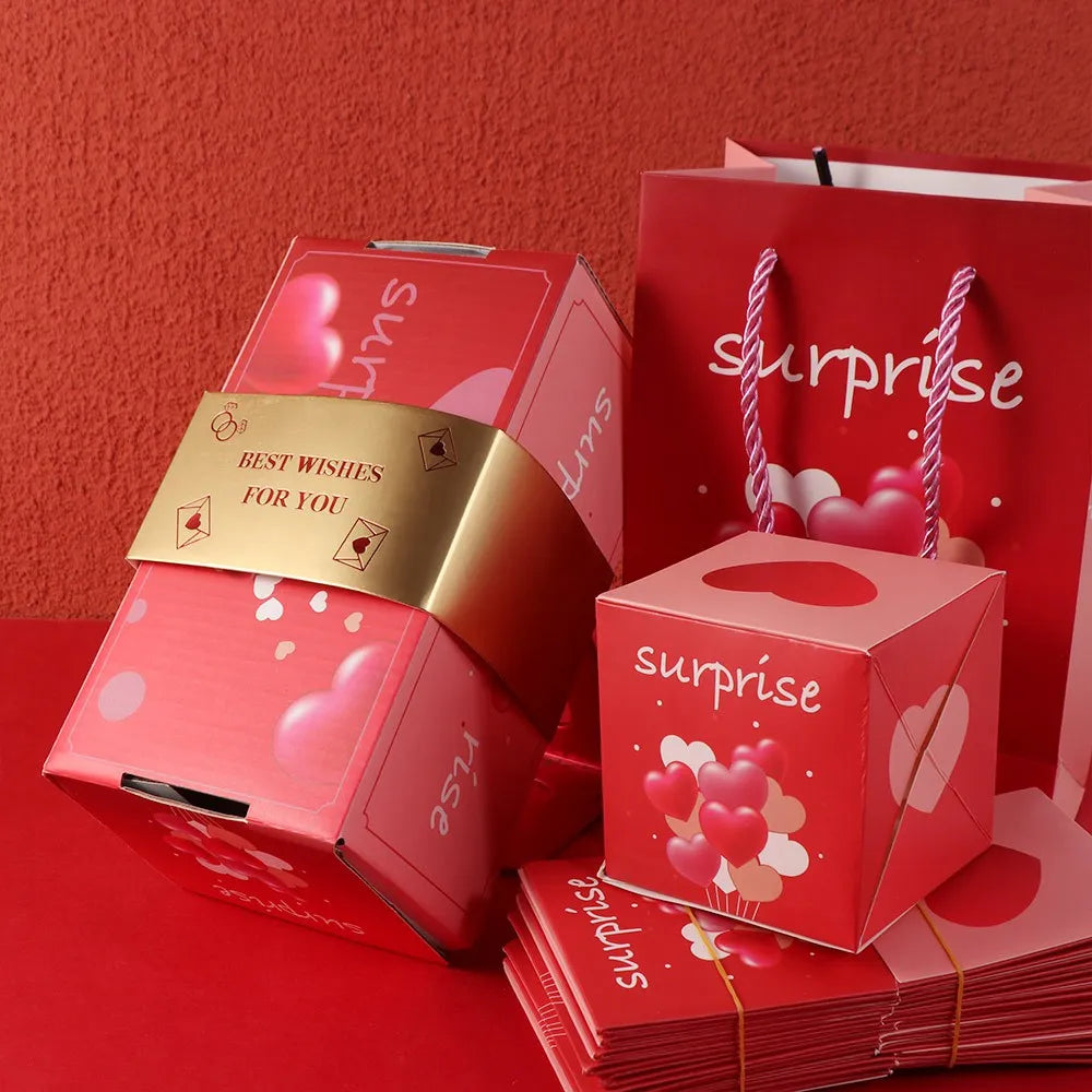 A stack of red and pink luxury pop-up surprise gift boxes with gold accents on a red surface.