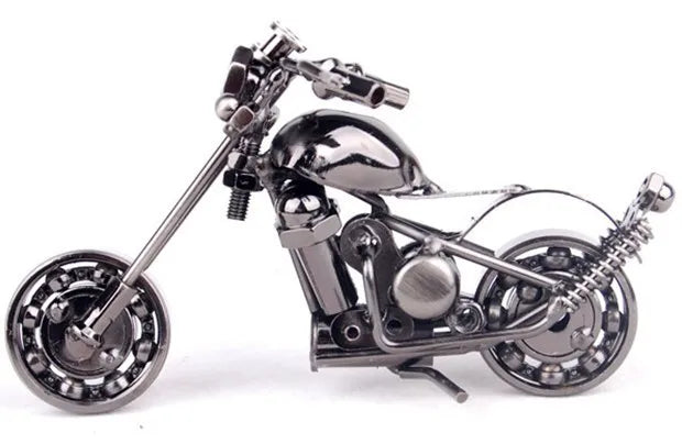 A handcrafted metal motorcycle model with chrome details and spoked wheels.