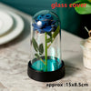 A blue artificial rose flower displayed inside a glass dome on a black base.