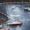 A vintage Formula 1 race scene featuring several cars on a track with Shell branding visible.