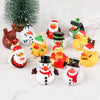 A collection of colorful rubber ducks and a green Christmas tree on a white marble surface.