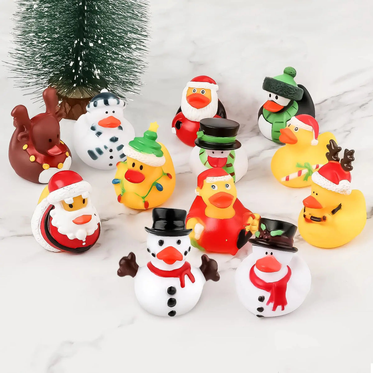 A collection of colorful rubber ducks and a green Christmas tree on a white marble surface.