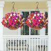 Two hanging baskets filled with vibrant artificial silk cloth flowers decorate a white porch railing.