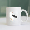 A white and black bird design sticker on a white ceramic mug.
