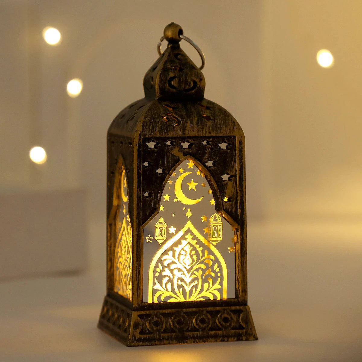 An elegant gold-toned LED lantern featuring a star and crescent moon design, illuminated with warm light.