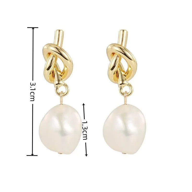 Elegant gold bean spliced pearl drop earrings with a textured link and a smooth pearl drop.