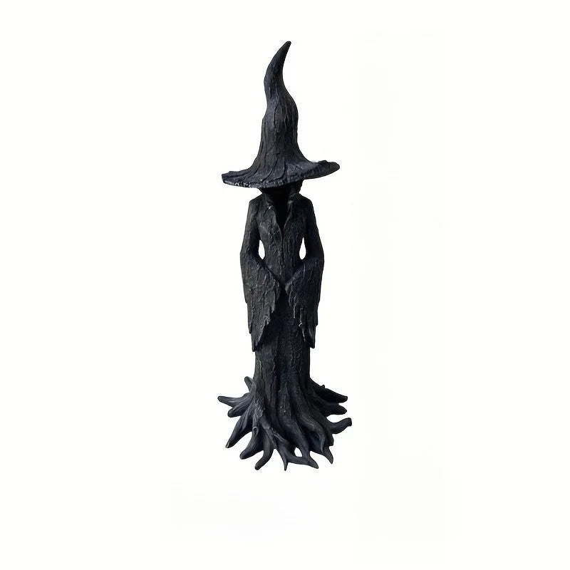Una estatua oscura y esculpida de una bruja con un sombrero ancho y cabello fluido.