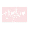 A pink card with white cursive text that reads Thank you and includes a heart symbol.
