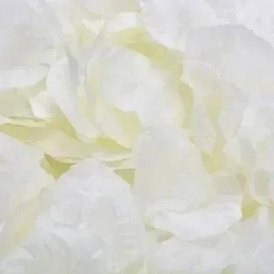 Close-up of white and pale yellow silk rose petals used for event decoration.