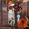 A display of ceramic book-shaped vases featuring vintage finishes and floral arrangements.