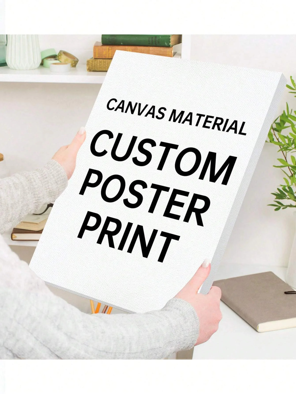 A person holds up a white canvas material poster with black text that reads Canvas Material Custom Poster Print