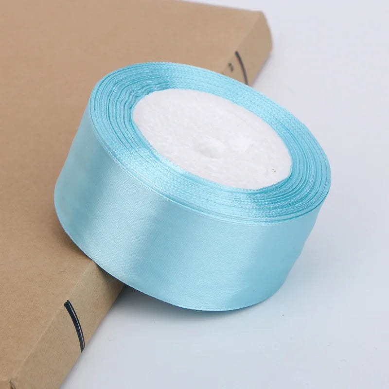 Roll of light blue satin ribbon with white filler for crafts and gift wrapping