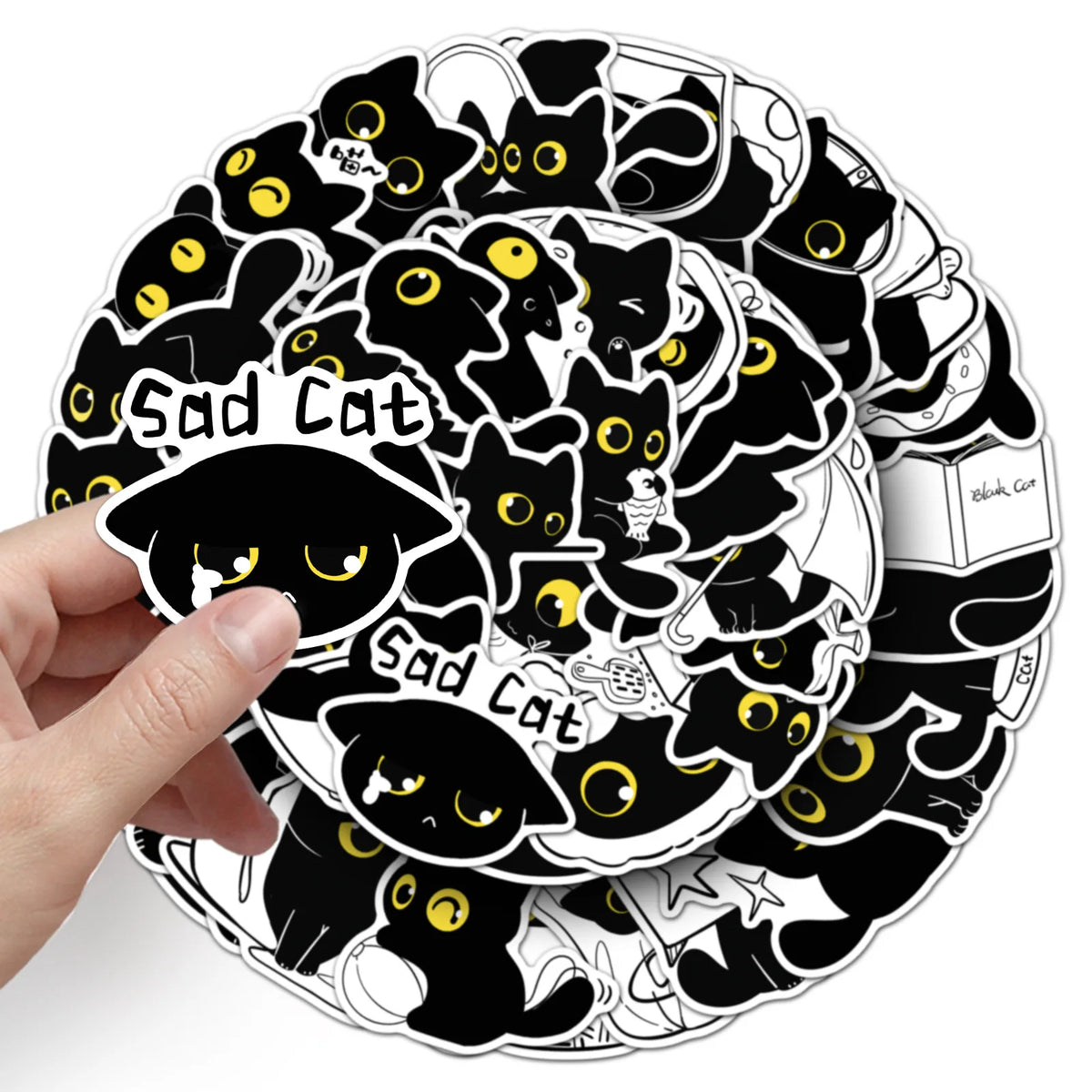 A hand holds a circular sticker design featuring multiple sad black cats with yellow eyes.