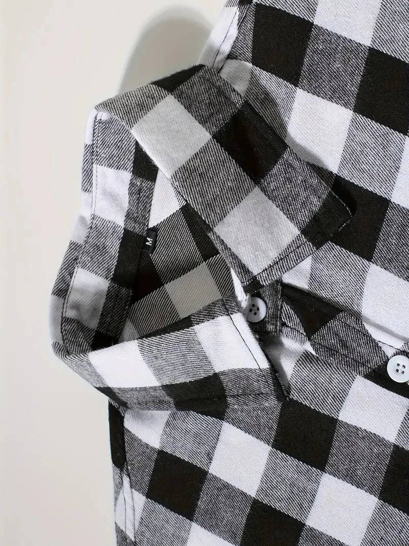 Close-up of a men's black and white plaid flannel shirt sleeve showing the fabric texture and button detail.