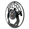 A black vintage vinyl record wall clock featuring a silhouette of a person and a clock face.