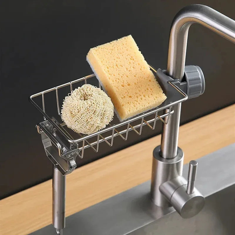 A faucet-mounted kitchen organizer with a drying rack holding a sponge and a block of yellow soap