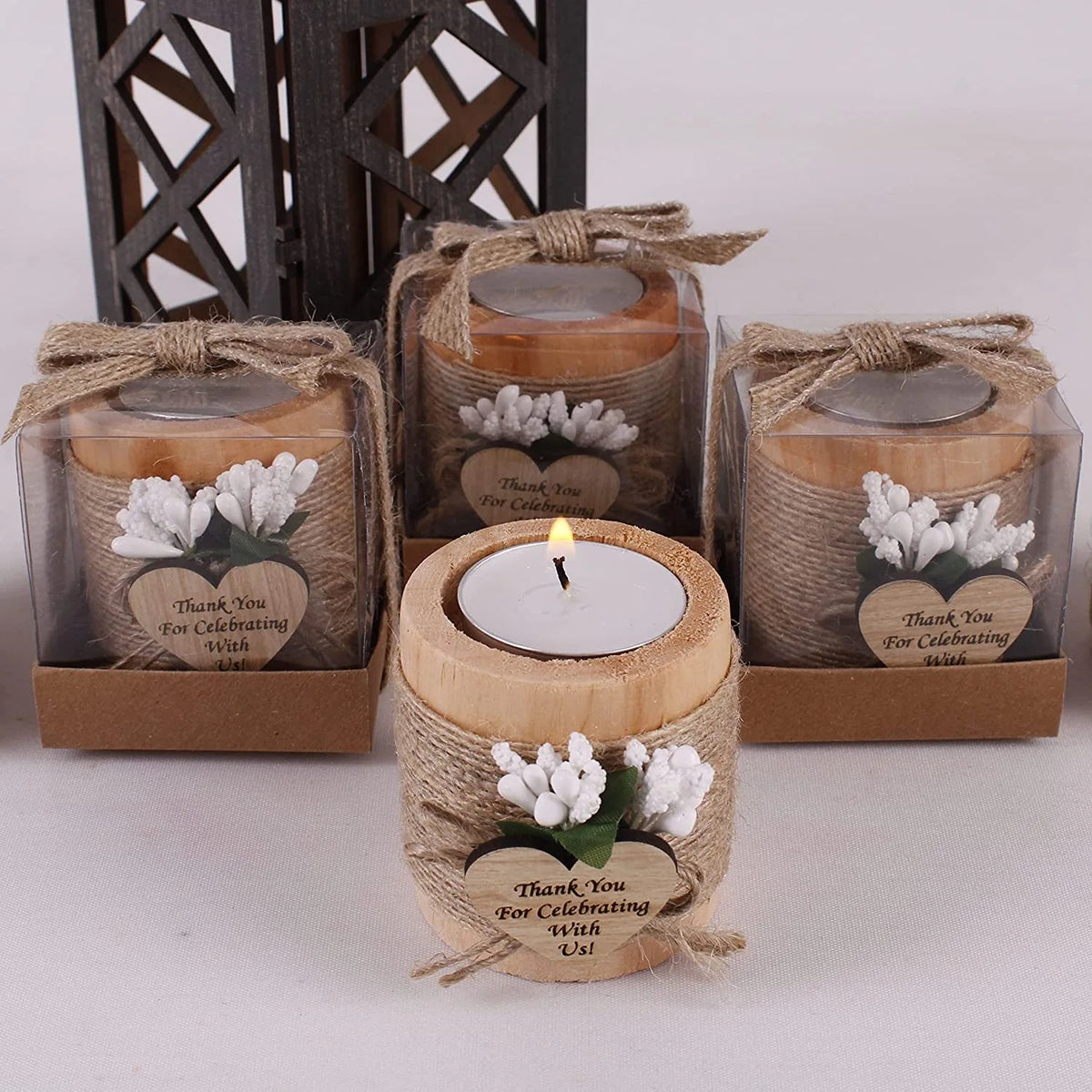 A collection of handcrafted wooden tealight candle holders tied with twine, used as wedding favors or gifts.