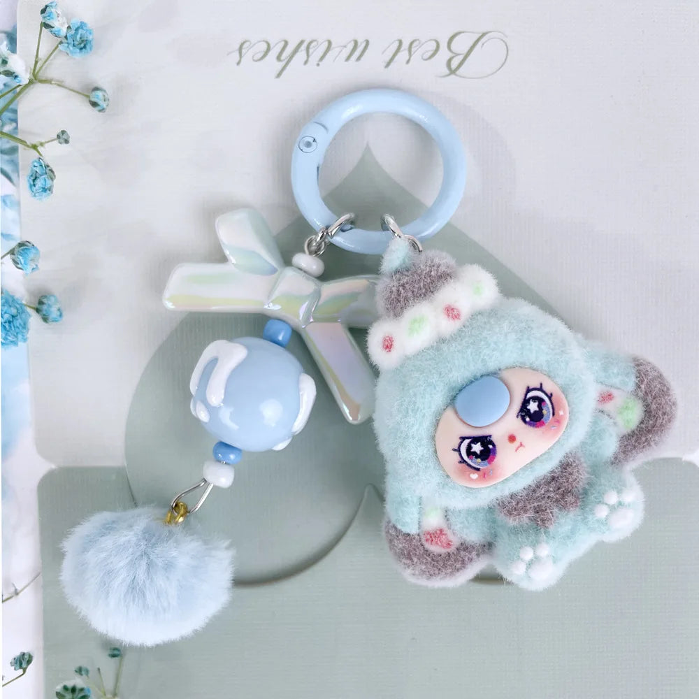 A cute light blue plush keychain charm featuring a face and a pink and white butterfly attached to a silver ring.