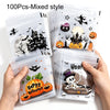A hand holds a stack of 100 clear self-adhesive treat bags featuring Halloween themed designs like bats pumpkins and spooky s