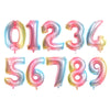 A set of foil balloons shaped like the numbers 0 through 9 in a rose gold and silver gradient color.