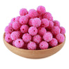 A pile of bright pink textured resin beads for jewelry making