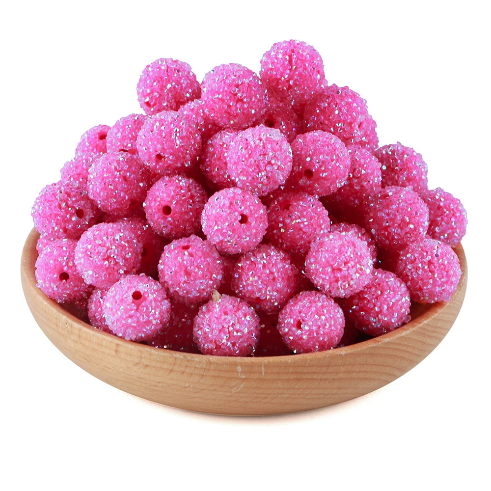 A pile of bright pink textured resin beads for jewelry making