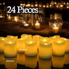 A collection of 24 glowing yellow LED tea light candles displayed on a dark surface.