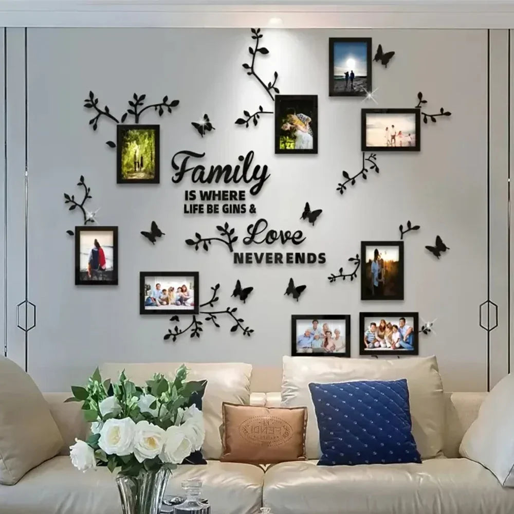 A wall display featuring black silhouette tree decals and framed photos on a light gray wall.
