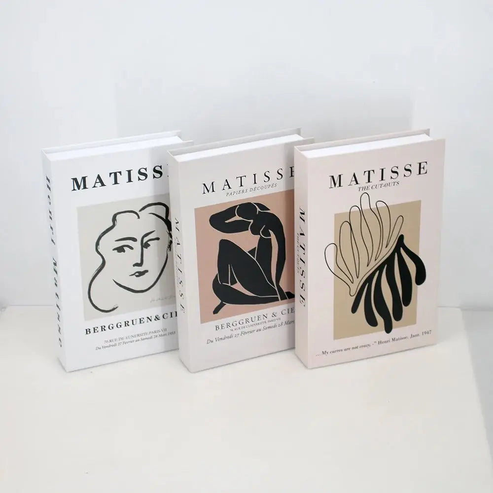 A set of three modern decorative fake books titled Matisse by Bergruen & Cie in white and beige covers.