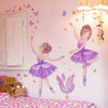 Un mur rose présente une illustration aquarelle d'une fille en robe violette avec des accents papillons et une lampe rose.