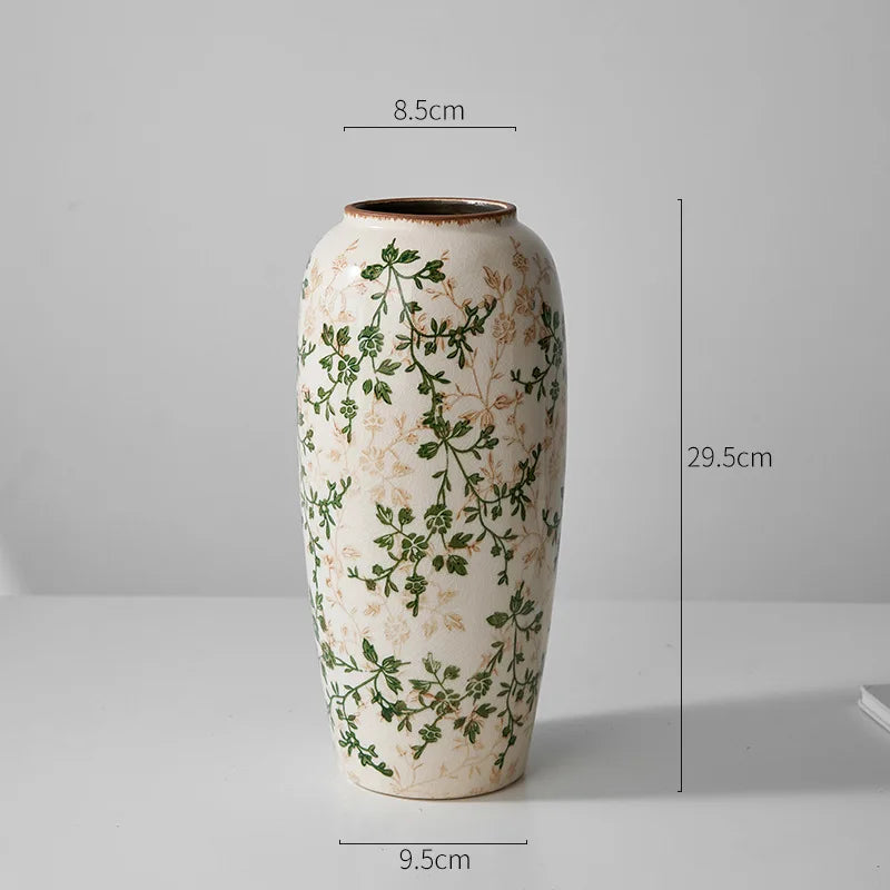 A tall ceramic milk pitcher with a pastoral green and beige floral design.
