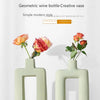 A light green geometric ceramic vase with a rectangular opening displayed on a white background.