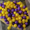 A clear bag filled with yellow and purple foam beads for crafting and decoration.
