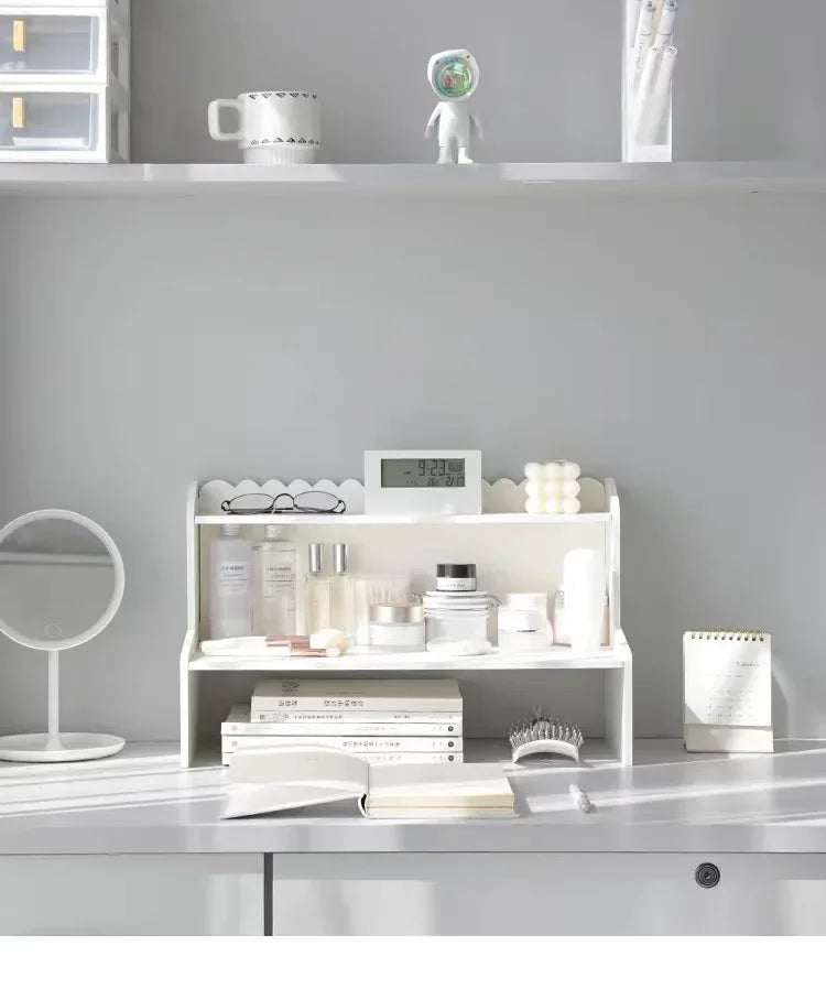 A white two-layer desktop organizer shelf displaying various skincare and beauty products.