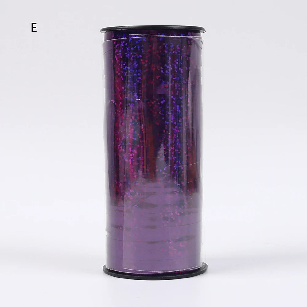A cylindrical roll of glitter curling ribbon in purple with sparkling accents.