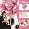 Eine Frau hält einen schwarzen Herzballon, neben einem Kleinkind stehen rosa Herzfolieballons.