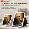 Folding makeup mirror with a light-up screen displayed on a white surface.