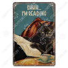 Décor mural vintage en métal représentant un chat noir lisant un livre avec le texte Shhh je lis