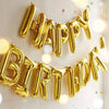 A golden foil balloon banner spelling out Happy Birthday strung across a white background.