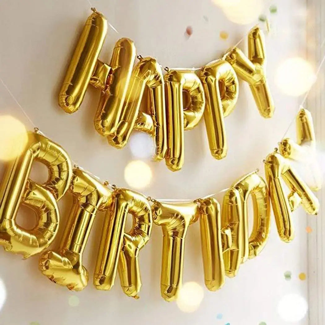 A golden foil balloon banner spelling out Happy Birthday strung across a white background.