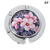 Silver foldable handbag hook with a floral design inset