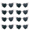 A set of heart-shaped sunglasses with black lenses and white frames.