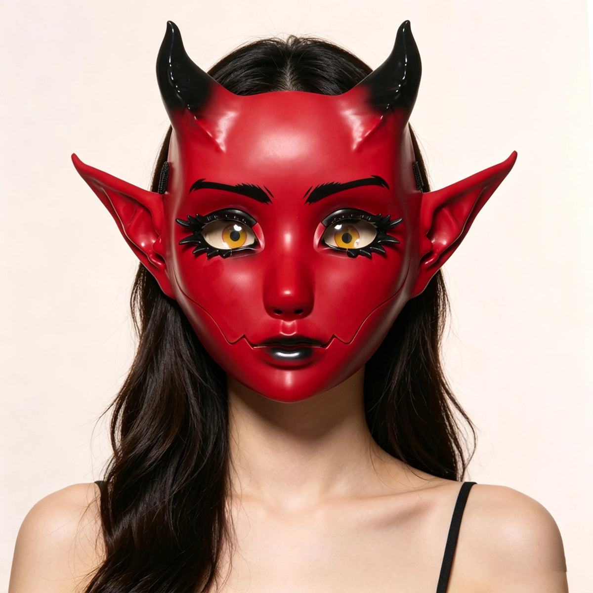 A woman wearing a red horned fantasy creature mask with black eyeliner and gold accents.