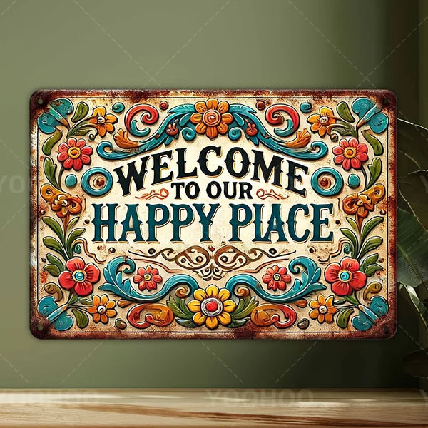 A rustic aluminum sign with floral design reads Welcome to Our Happy Place in ornate script.