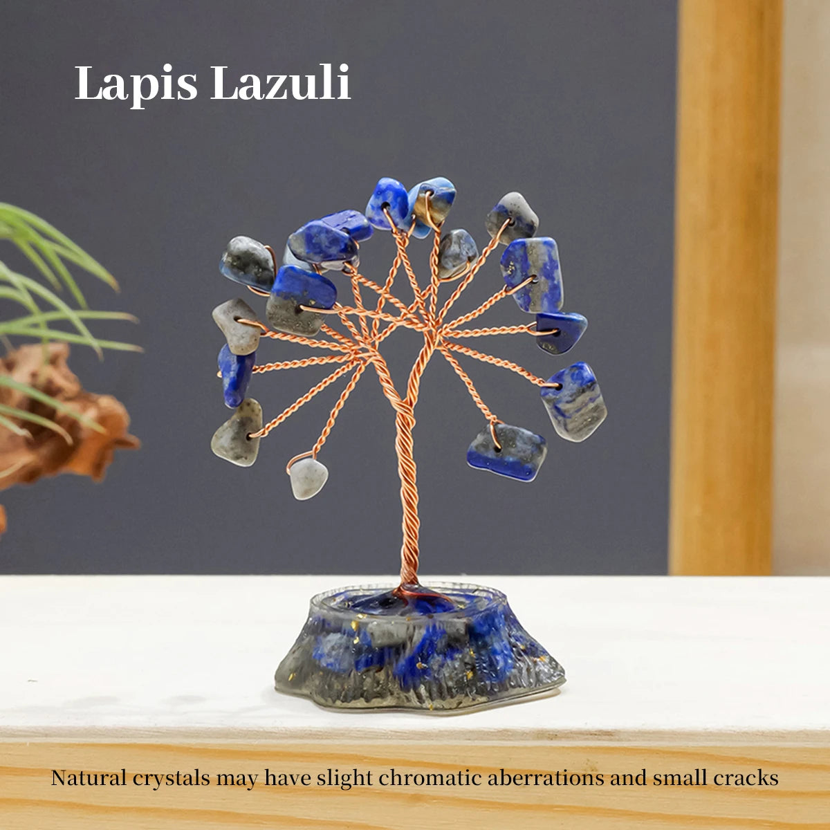 A crystal tree sculpture made of blue lapis lazuli stones with natural wire branches on a dark base.
