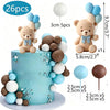 A tiered cake decorated with blue and brown foam balls and bear toppers, featuring light blue frosting.