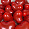 A close-up of glossy red heart-shaped latex balloons used for party decoration.