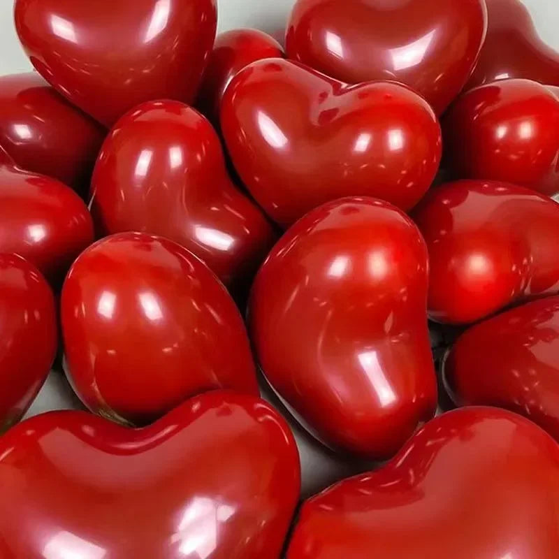 A close-up of glossy red heart-shaped latex balloons used for party decoration.