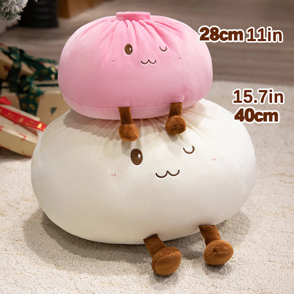 A pink dumpling plush pillow with brown ears rests on a white fluffy surface.