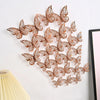 A set of 3D hollow butterfly wall decals in a rose gold color arranged on a white wall.